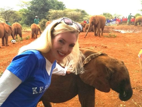 woman posing with baby elephant